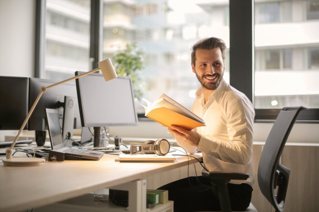 A man smiling at his desk