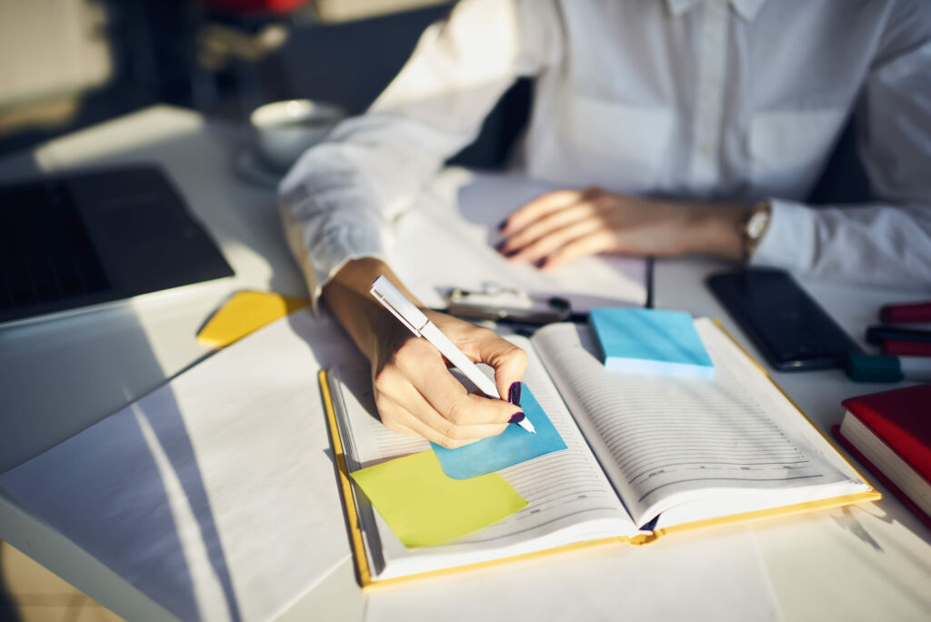 A woman writing on a post-it note